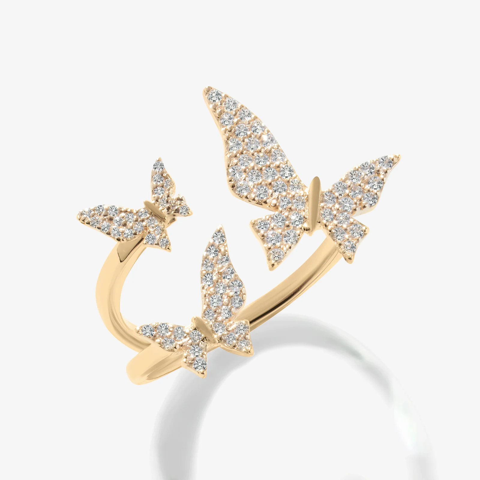 Jewellery — Three butterflies trace an open silhouette, their wings alive with light.