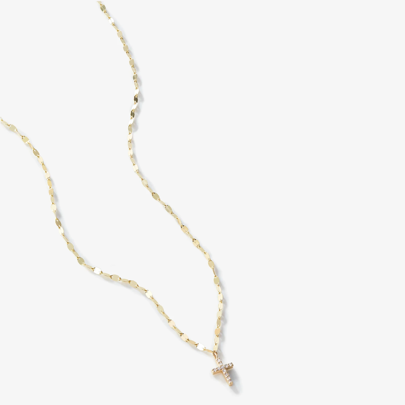 Jewellery — A delicate chain with petal-like links and a light-catching cross pendant.